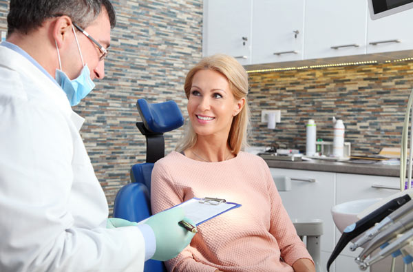 Woman talking to dentist during dental exam